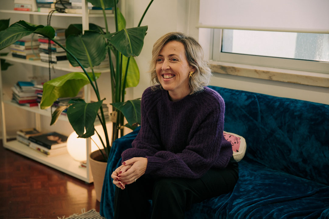 a woman seating in a couch and smiling